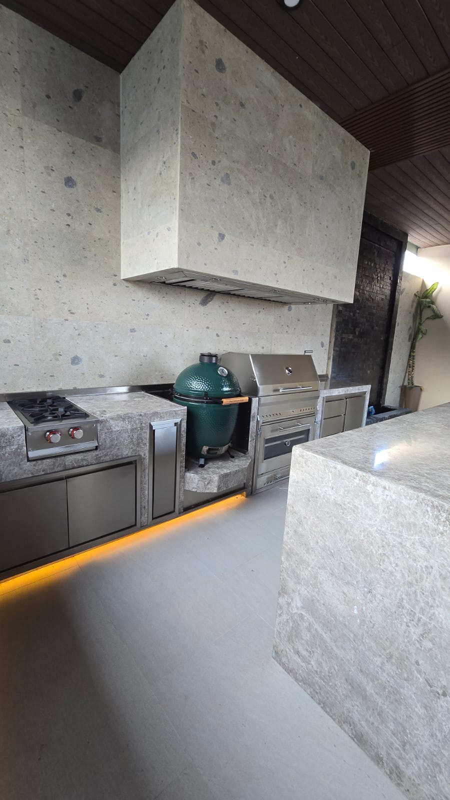 Cocina exterior en granito negro con campana de acero